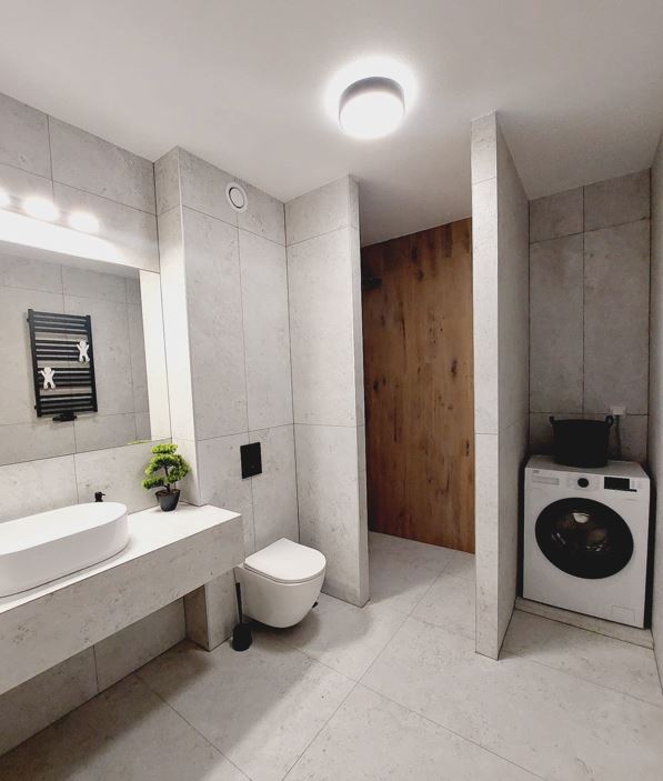Nowoczesna łazienka z prysznicem i pralką – apartament Kraków, AWG Apartments