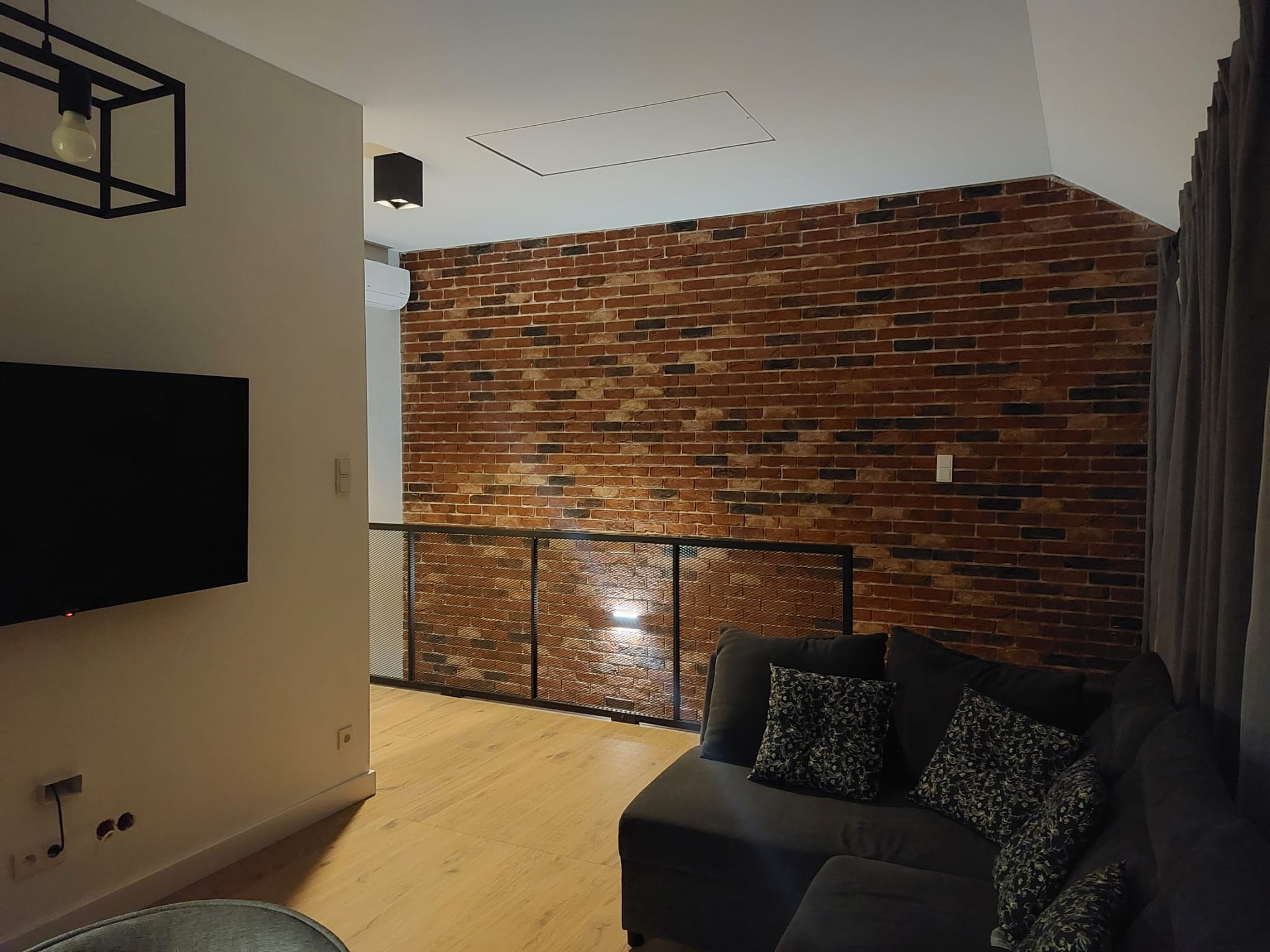 Salon z ceglaną ścianą i TV – Taras & Widok